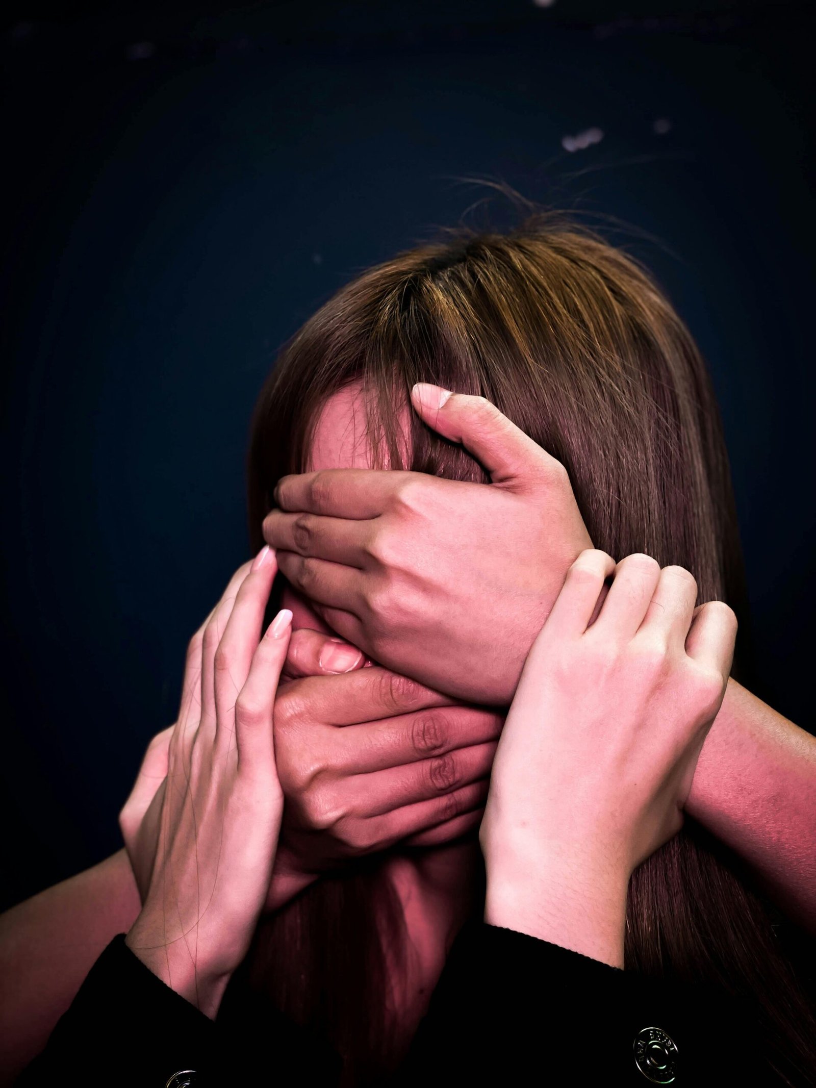 A womans face being coverd by hands